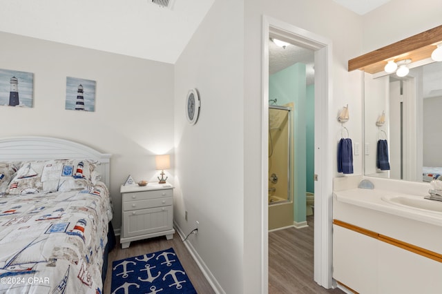 bedroom featuring sink, ensuite bathroom, and light hardwood / wood-style floors