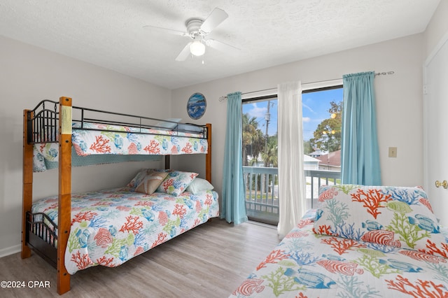 bedroom with hardwood / wood-style floors, ceiling fan, access to exterior, and a textured ceiling