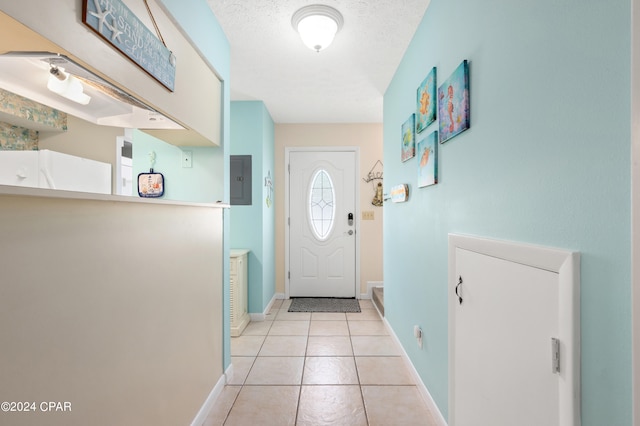 doorway featuring a textured ceiling, electric panel, and light tile patterned flooring