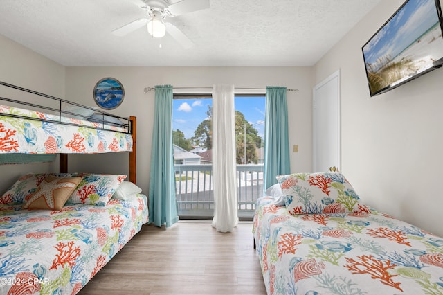 bedroom featuring ceiling fan, a textured ceiling, access to outside, and wood-type flooring