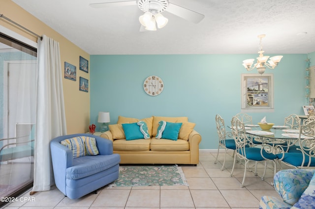 living room featuring a textured ceiling, ceiling fan with notable chandelier, and light tile patterned flooring