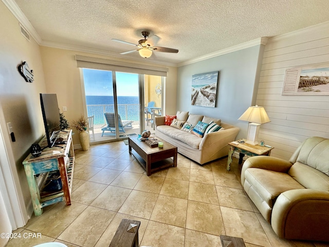 tiled living room featuring ornamental molding, a textured ceiling, ceiling fan, and wooden walls