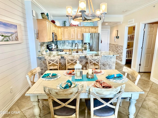 kitchen with stainless steel appliances, an inviting chandelier, crown molding, and wooden walls