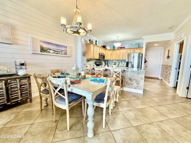 tiled dining room with crown molding, a textured ceiling, wood walls, and an inviting chandelier