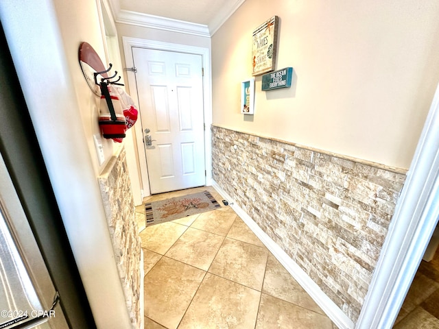 doorway to outside with ornamental molding and tile patterned flooring