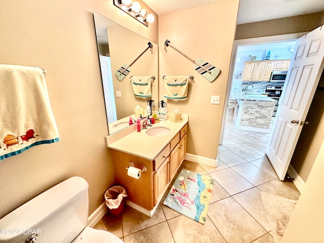 bathroom featuring vanity, toilet, tile patterned floors, and a textured ceiling