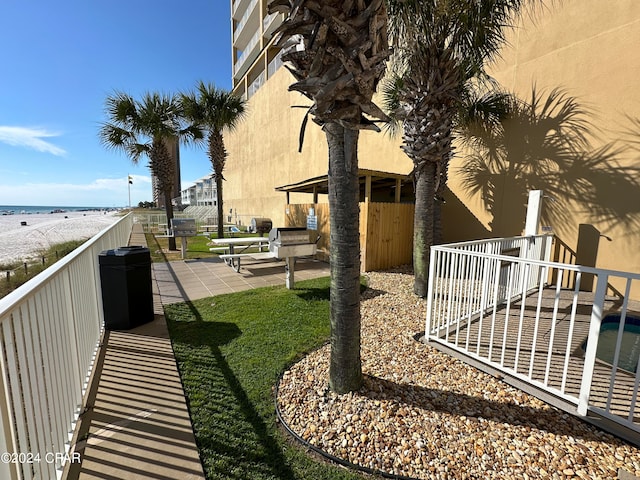 view of yard featuring a patio area, a beach view, and a water view