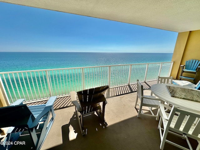 balcony featuring a water view and a view of the beach