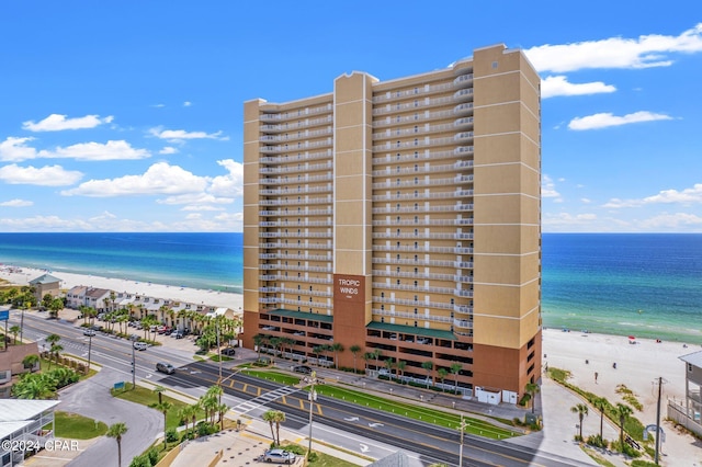 view of building exterior featuring a view of the beach and a water view