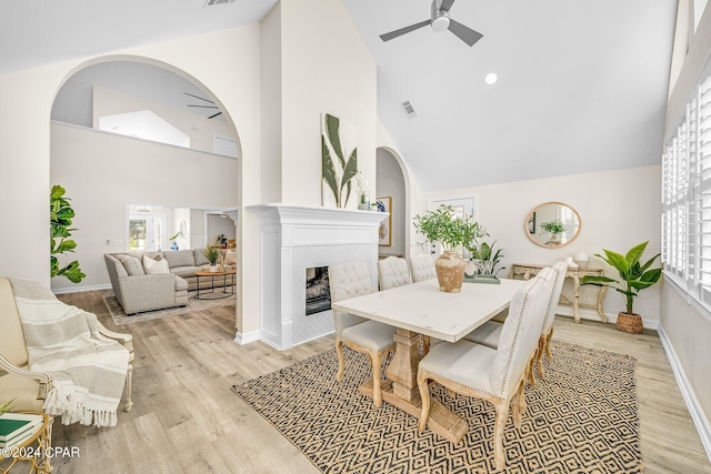 dining space with high vaulted ceiling, ceiling fan, light hardwood / wood-style flooring, and plenty of natural light