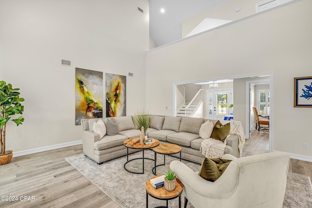 living room featuring a high ceiling and light hardwood / wood-style floors