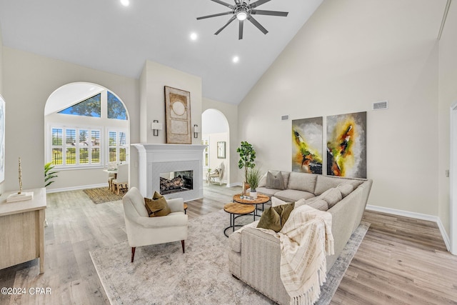 living room featuring high vaulted ceiling, ceiling fan, and light hardwood / wood-style flooring