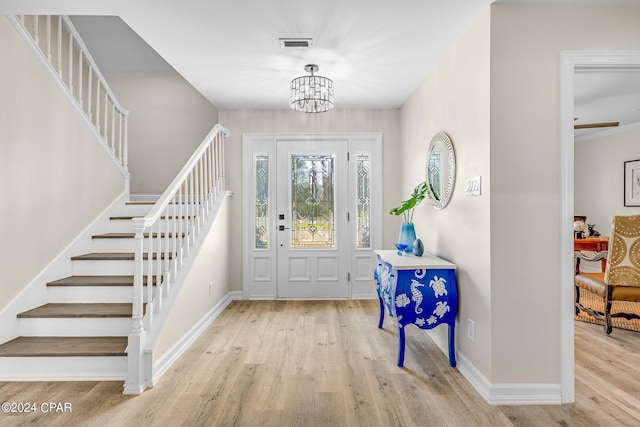 entrance foyer with an inviting chandelier and light hardwood / wood-style floors