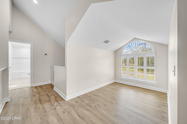 bonus room featuring light wood-type flooring and vaulted ceiling