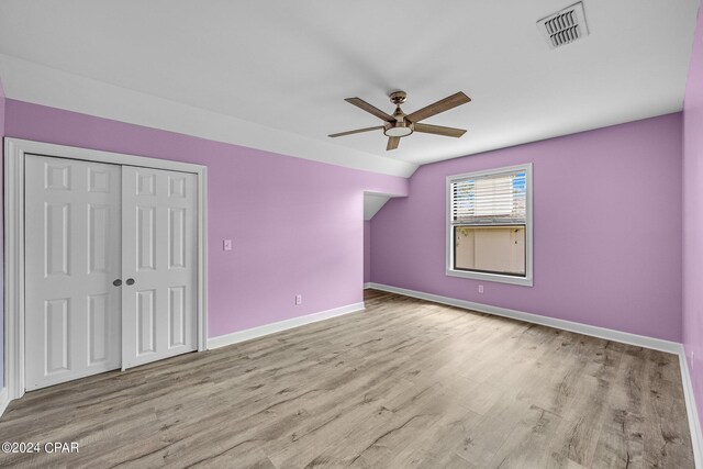 unfurnished bedroom featuring light wood-type flooring, ceiling fan, and a closet