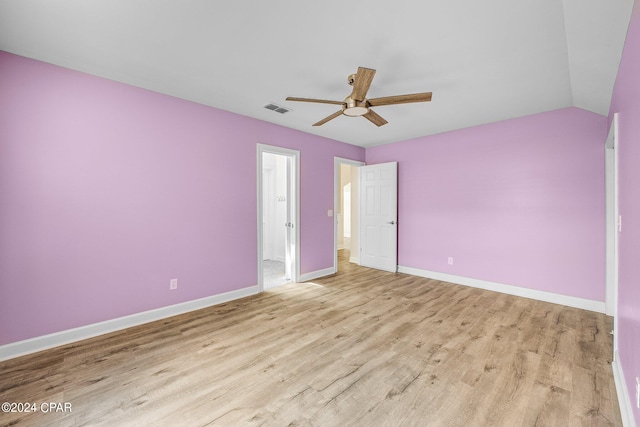 spare room featuring light wood-type flooring, lofted ceiling, and ceiling fan