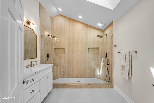 bathroom with a tile shower, vanity, tile patterned flooring, and lofted ceiling with skylight