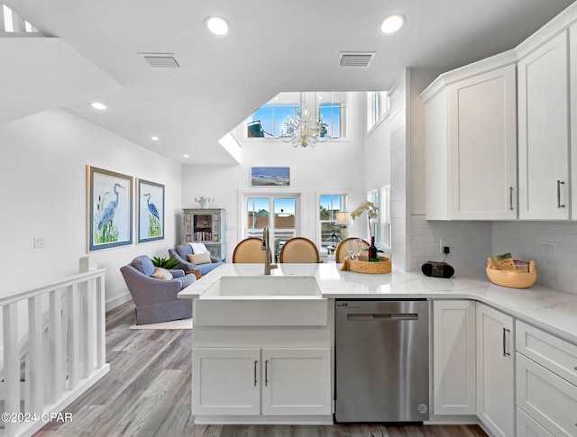 kitchen with white cabinets, dishwasher, light hardwood / wood-style floors, and kitchen peninsula