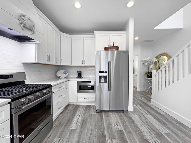 kitchen with white cabinetry, light countertops, tasteful backsplash, light wood-type flooring, and stainless steel appliances