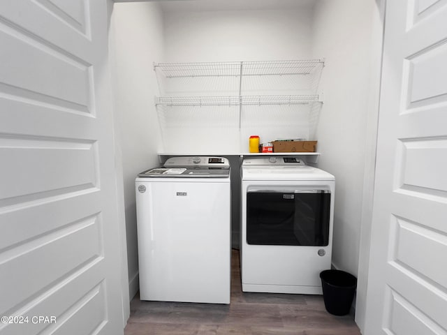 clothes washing area with washer and dryer and dark wood-type flooring