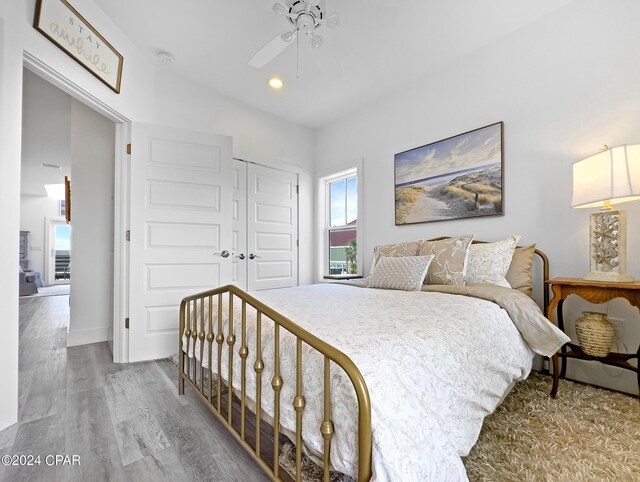 bedroom featuring baseboards, a closet, wood finished floors, and ceiling fan