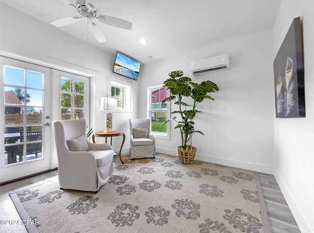 sitting room featuring a wall mounted air conditioner, baseboards, wood finished floors, recessed lighting, and a ceiling fan
