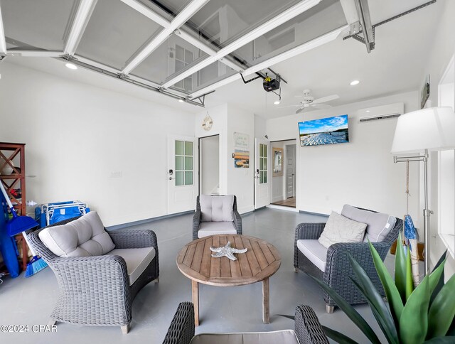 living room featuring ceiling fan and a wall unit AC