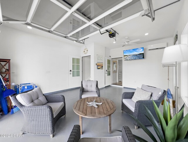 living area featuring recessed lighting, concrete floors, an AC wall unit, and a garage