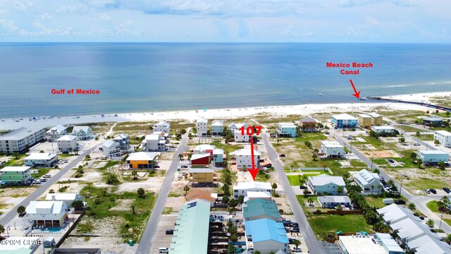 drone / aerial view featuring a water view and a view of the beach