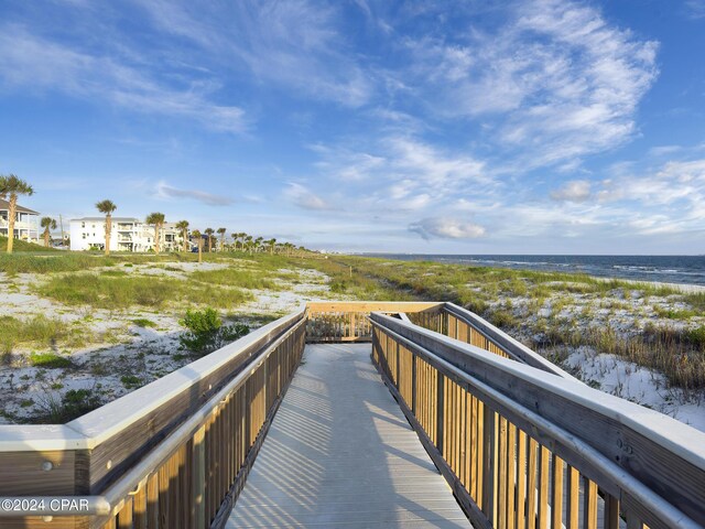 view of property's community with a water view and a beach view