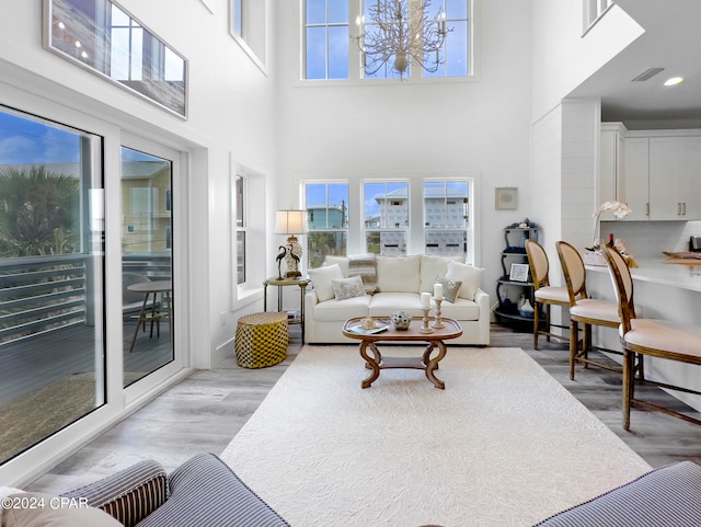 living room featuring light wood-type flooring and a towering ceiling