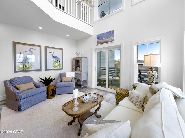 living room featuring a high ceiling, wood finished floors, and recessed lighting