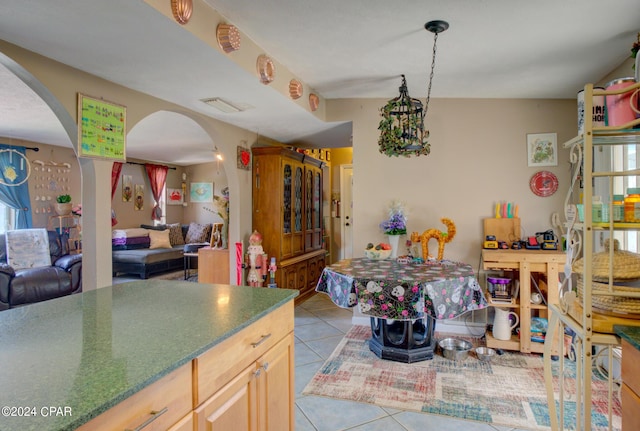 kitchen featuring arched walkways, open floor plan, visible vents, and light tile patterned floors