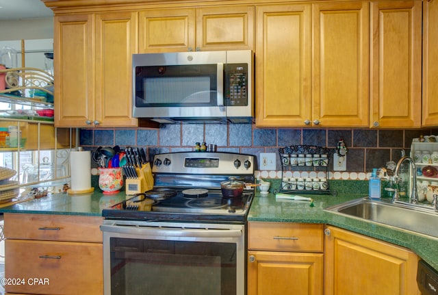 kitchen featuring appliances with stainless steel finishes, tasteful backsplash, and sink