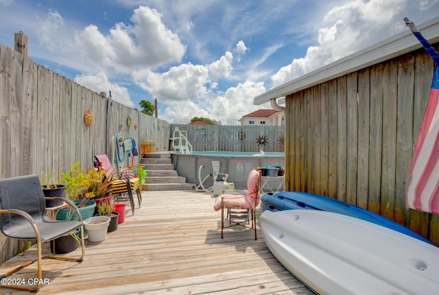 wooden deck featuring a fenced backyard and a fenced in pool