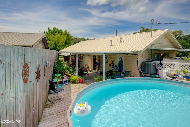 view of pool with a deck and central air condition unit