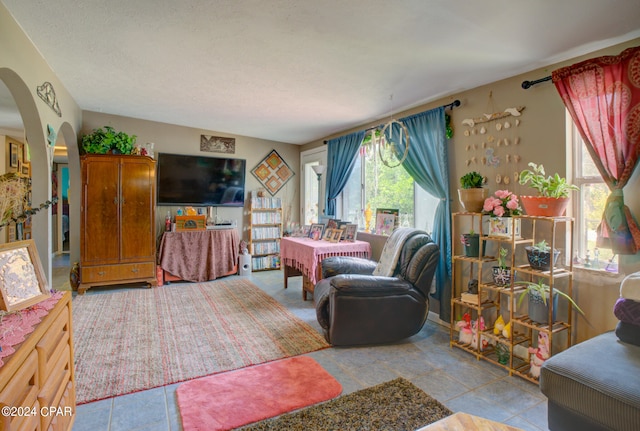 living room with a textured ceiling and light tile patterned flooring