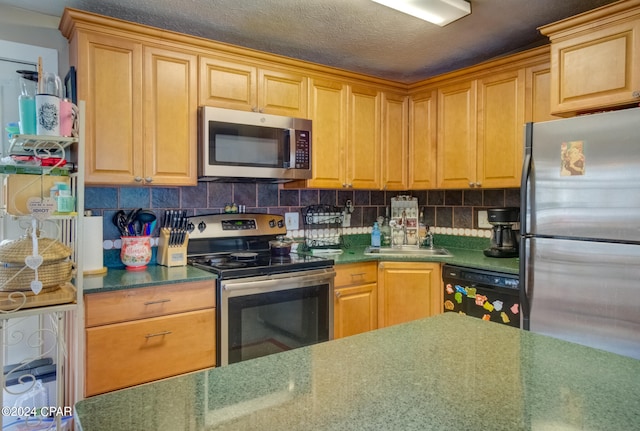 kitchen featuring appliances with stainless steel finishes, tasteful backsplash, sink, and a textured ceiling