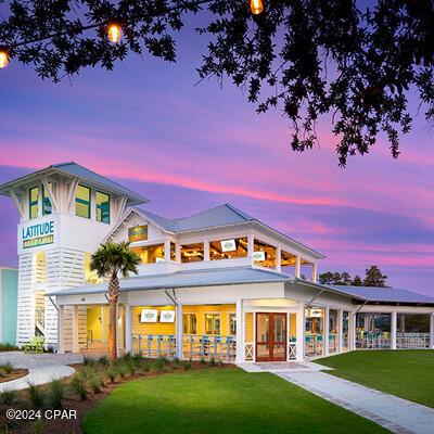 back house at dusk with a balcony and a yard