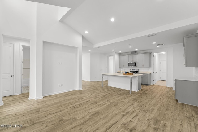 kitchen featuring an island with sink, gray cabinets, light hardwood / wood-style floors, and appliances with stainless steel finishes