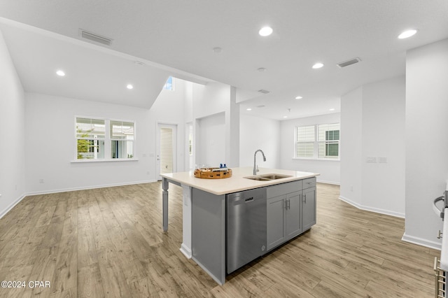 kitchen with sink, dishwasher, light hardwood / wood-style floors, a center island with sink, and gray cabinetry