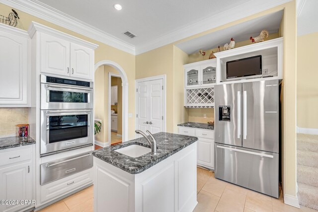 kitchen featuring sink, appliances with stainless steel finishes, dark stone counters, and white cabinets