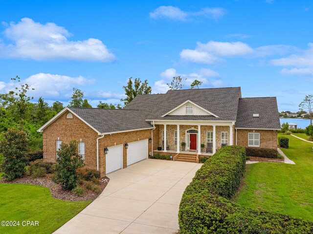 view of front of property with a front lawn, a garage, and a porch