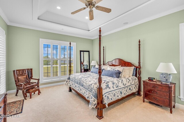 carpeted bedroom featuring a tray ceiling, ceiling fan, and ornamental molding