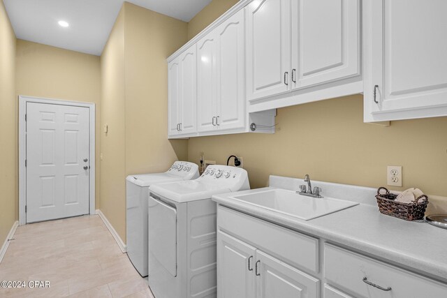 laundry area featuring cabinets, sink, and washing machine and dryer