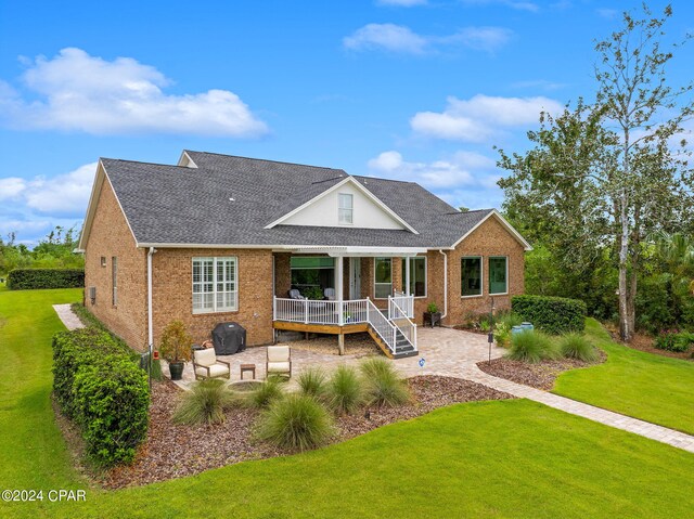 view of front facade with covered porch, a front yard, and a patio area