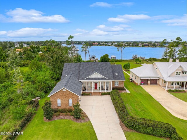 view of front of property with a water view and a front lawn