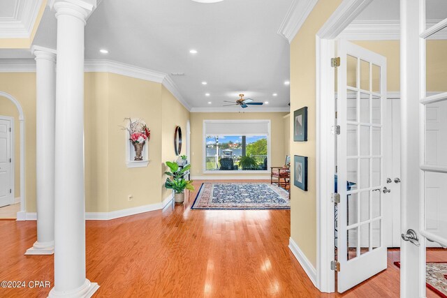 foyer entrance with decorative columns, crown molding, ceiling fan, and light hardwood / wood-style floors