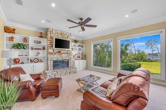 living room with crown molding, ceiling fan, light carpet, and a fireplace