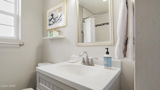 bathroom featuring vanity, toilet, and walk in shower